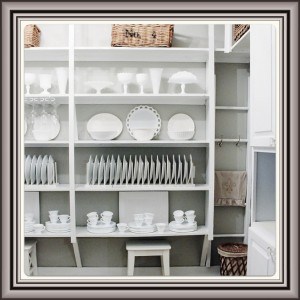 Image (10) A neatly organized white pantry with an assortment of white dishes, plates, and serving ware meticulously arranged on shelves, accompanied by wicker baskets for storage.