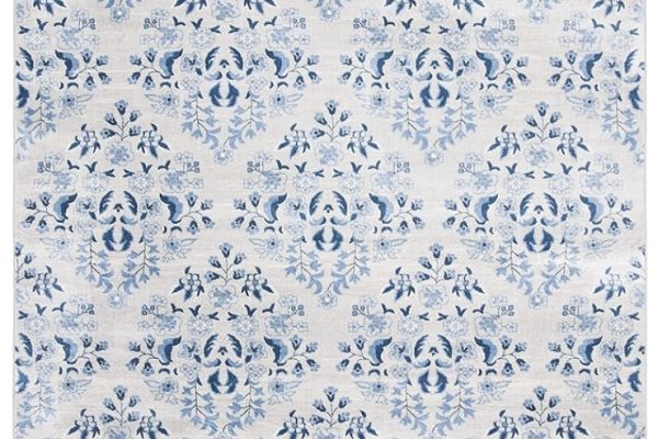 A rectangular area rug with an intricate, repeating damask pattern in shades of blue on a white background, creating an elegant and symmetrical design.